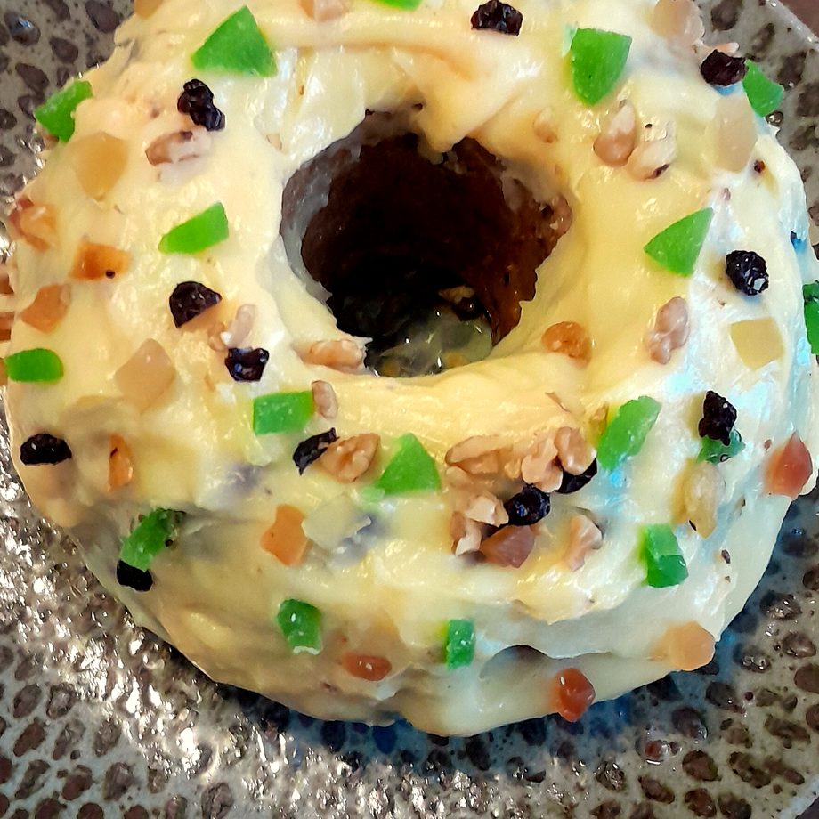 Bolo com cobertura branca, frutas cristalizadas e castanhas