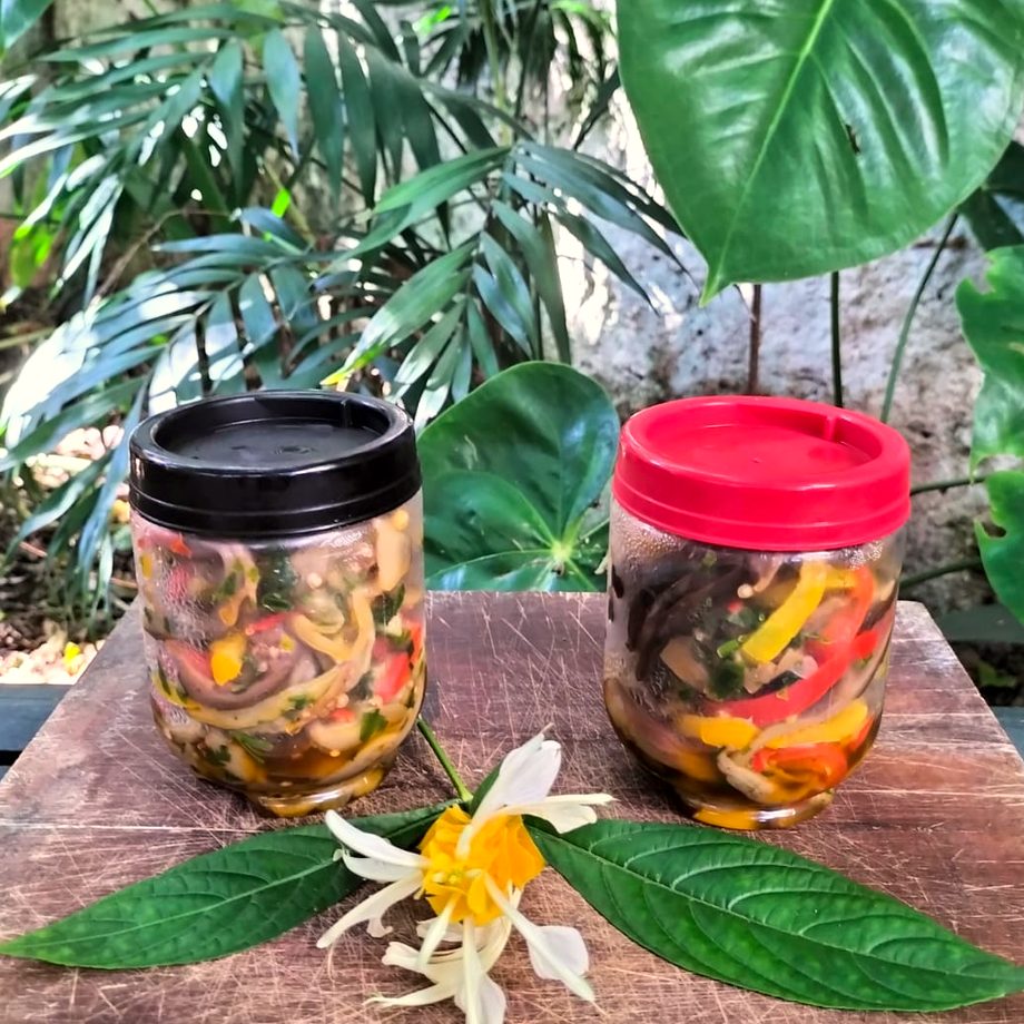 Potes de conserva sobre a madeira, com folhas e flor